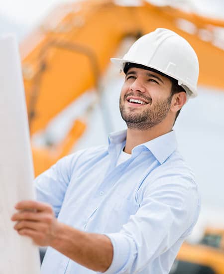 Site supervisor reviewing plans with excavation machinery in the background